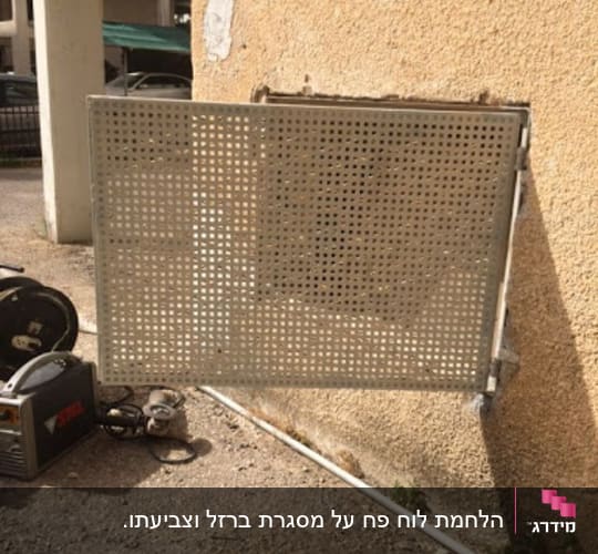 מסגרת מתכת מחוררת מחוברת לקיר חיצוני